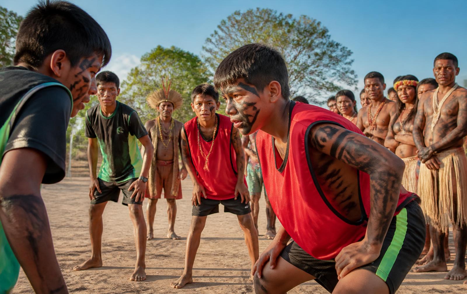 Jovens indígenas participando de atividade esportiva acompanhados pela comunidade